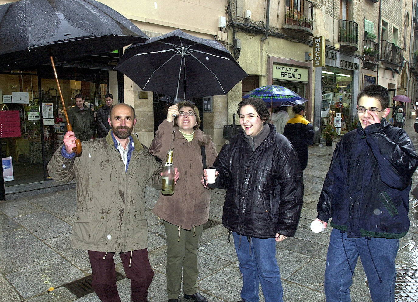 Afortunados por el 'gordo' de Navidad que cayó en Segovia hace veinte años brindan ante la administración del Corpus. 