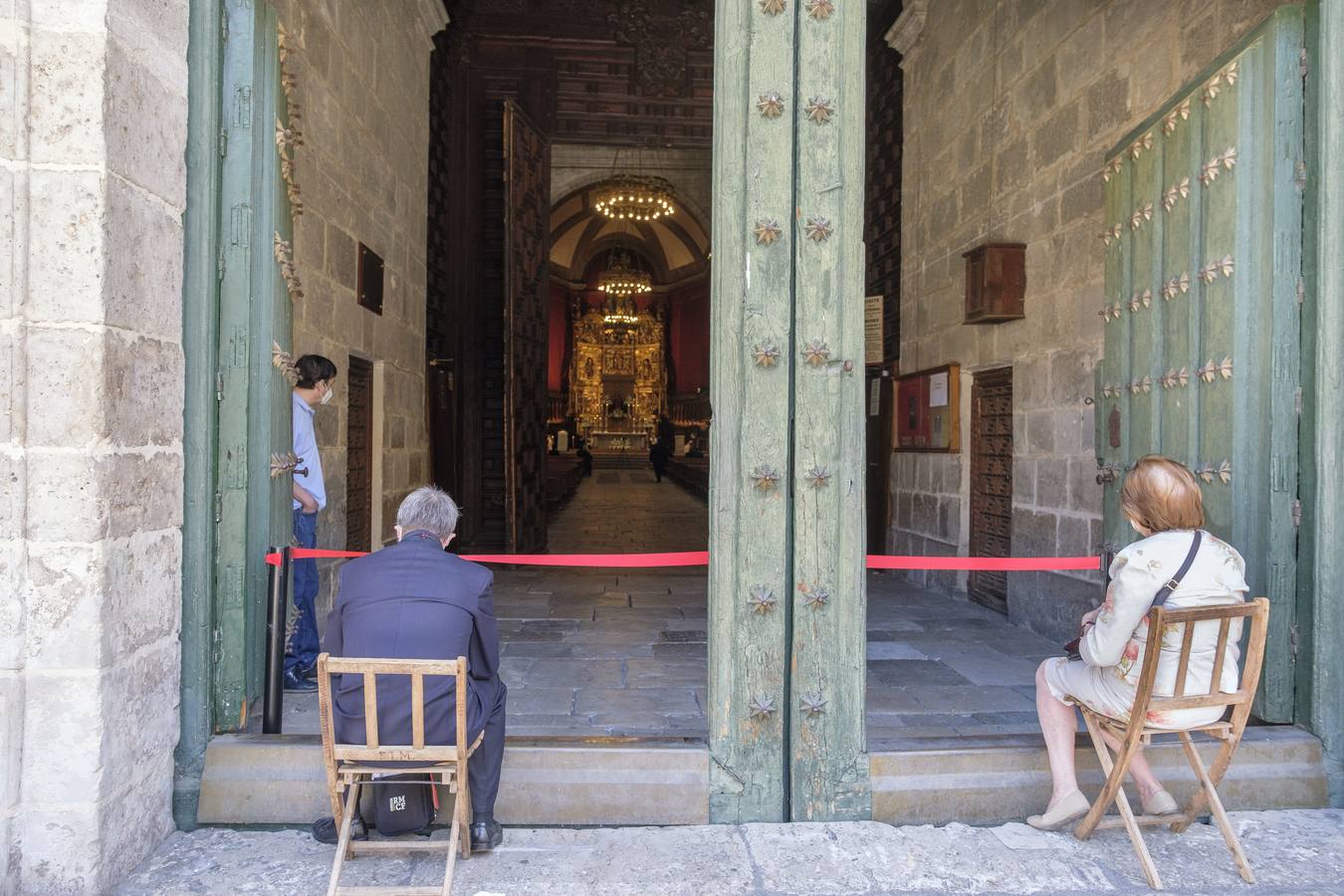 Suspendida la Semana Santa. Los actos religiosos se limitaron a alguna Misa en la Catedral con drásticas medidas de seguridad. En la imagen dos feligreses escuchan la Eucaristía en las puertas de la Catedral.