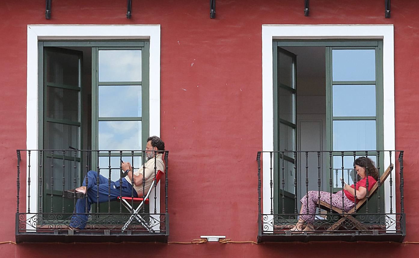 El confinamiento hizo recuperar a los vecinos los balcones para descansar al aire libre. En la imagen dos vallisoletanos descansan en su casa de la Plaza Mayor de Valladolid. 