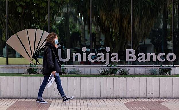 Una mujer pasa frente a la sede de Unicaja en Málaga 