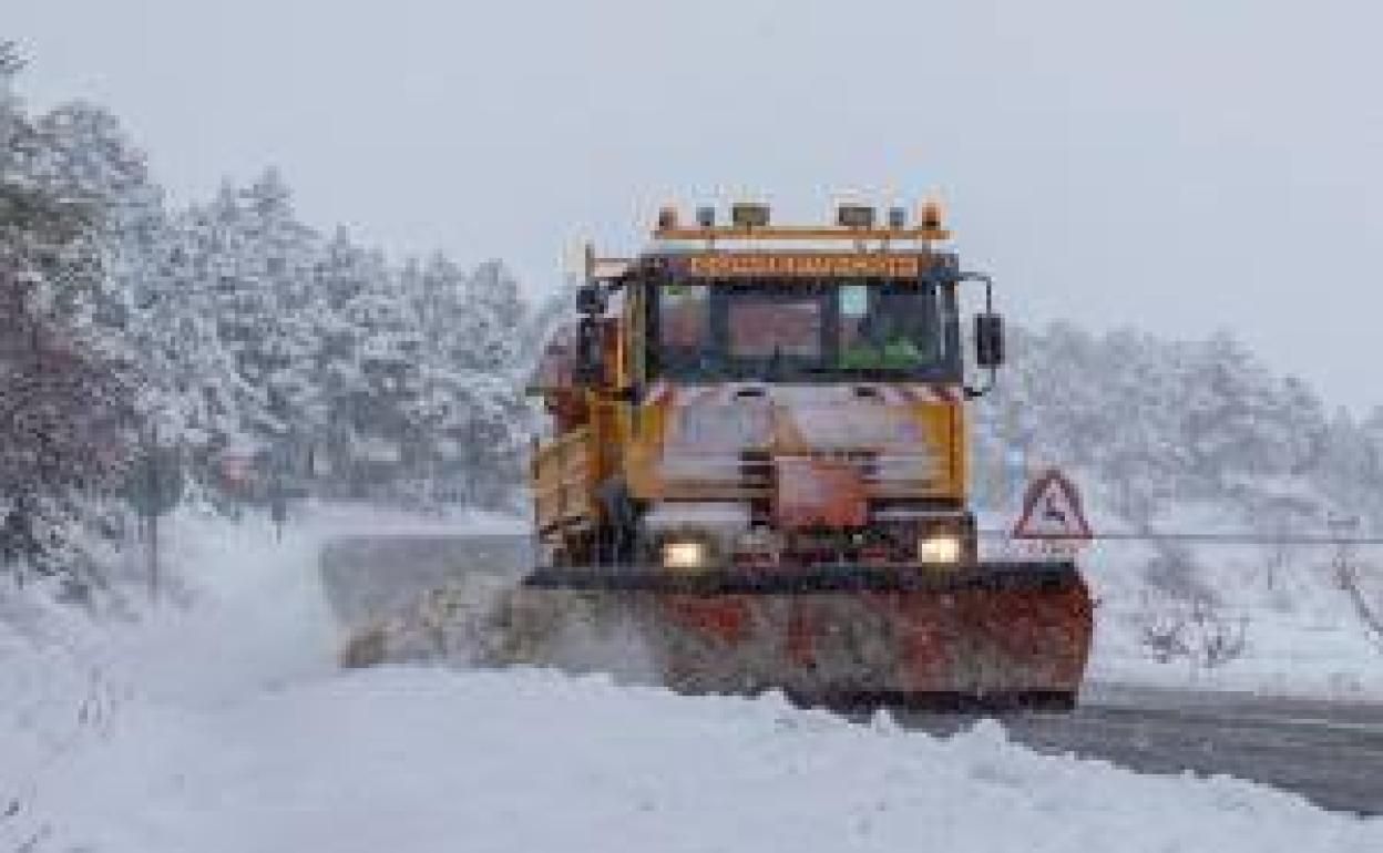 Una máquina quitanieve limpiando la carretera nevada. 