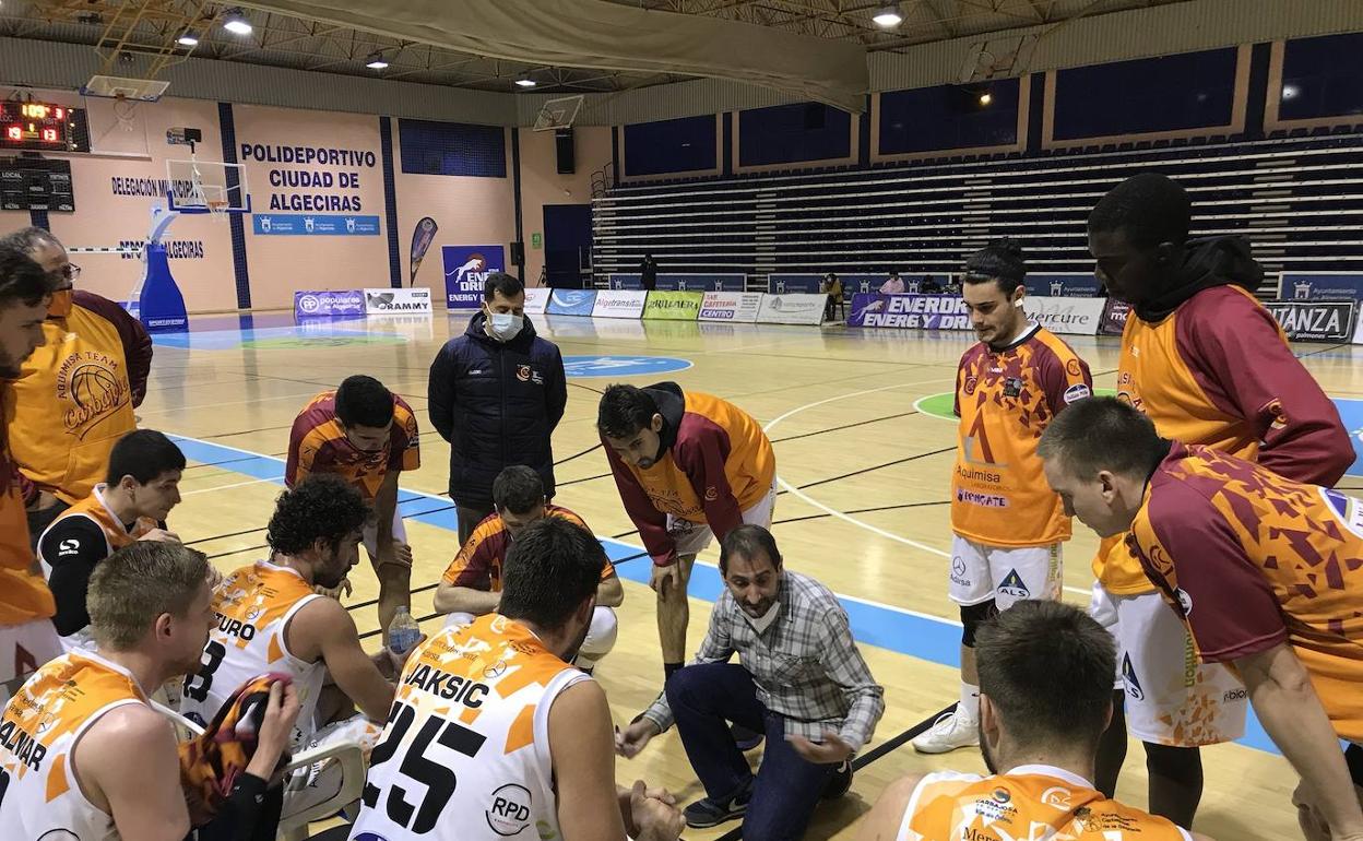 Los jugadores del Aquimisa escuchan a su técnico en el pabellón de Algeciras. 