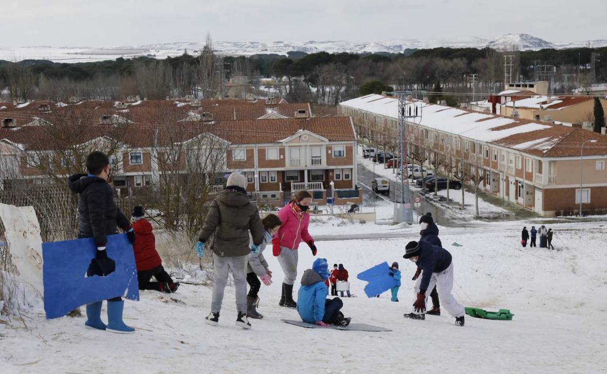 Varios niños se divierten con la nieve este domingo en Peñafiel. 