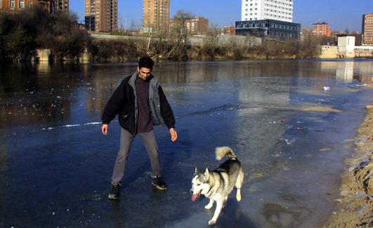Un joven camino junto a su perro por la orilla congelada del Pisuerga el 26 de diciembre de 2001.