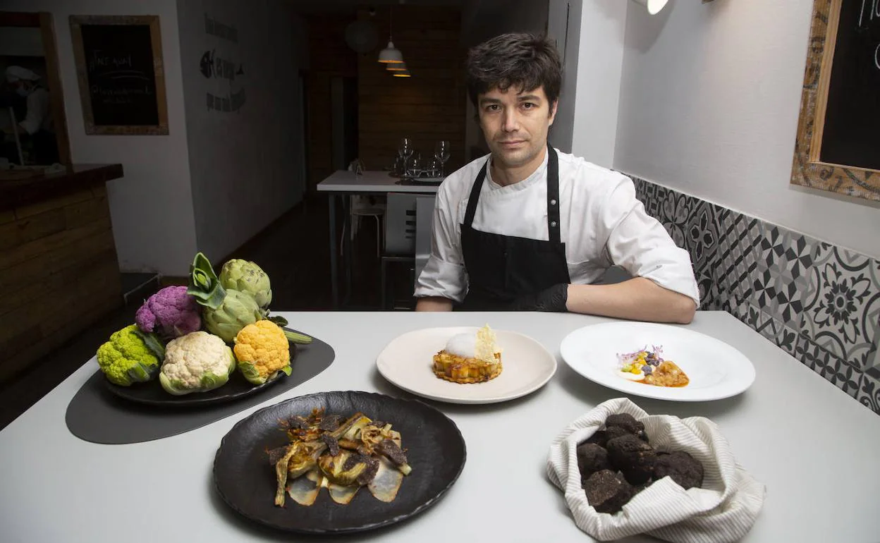 El cocinero Manuel Soler posa con las verduras y sus tres platos en su restaurante La Cocina de Manuel, en Valladolid. 