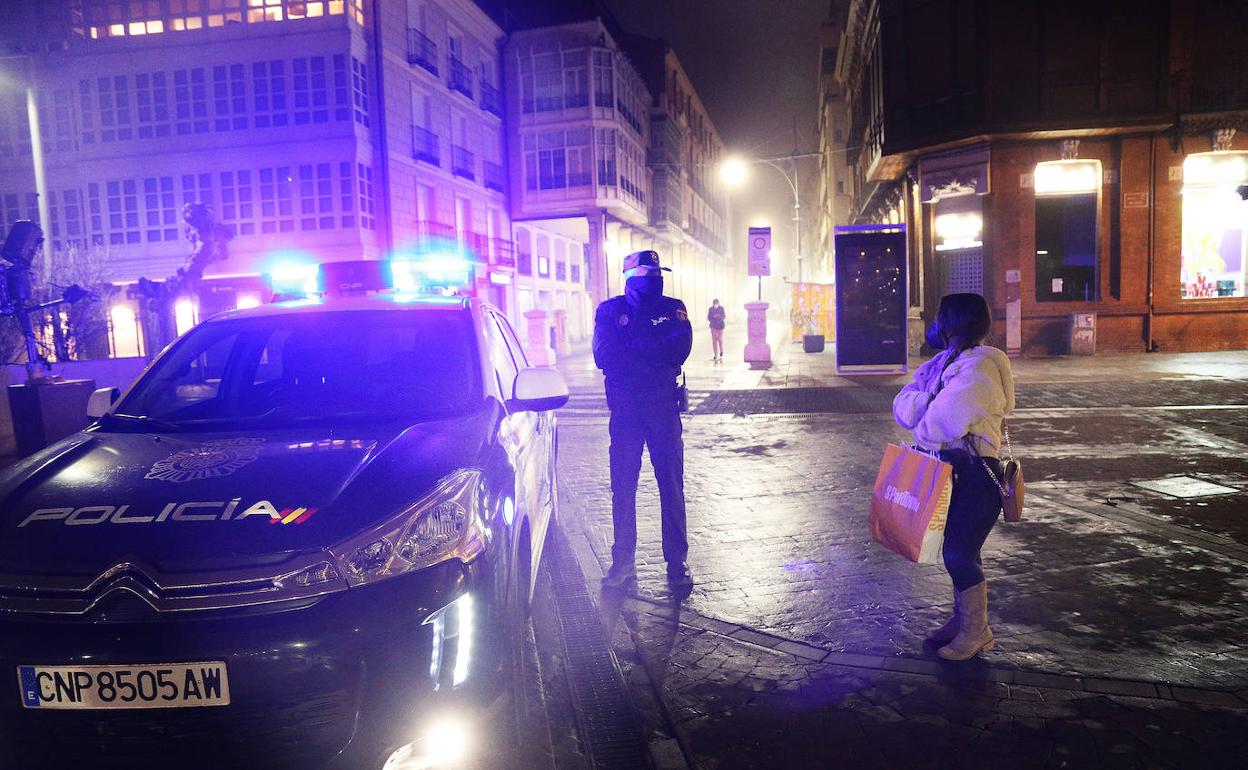 Un policía nacional informa a una mujer de los nuevos horarios.