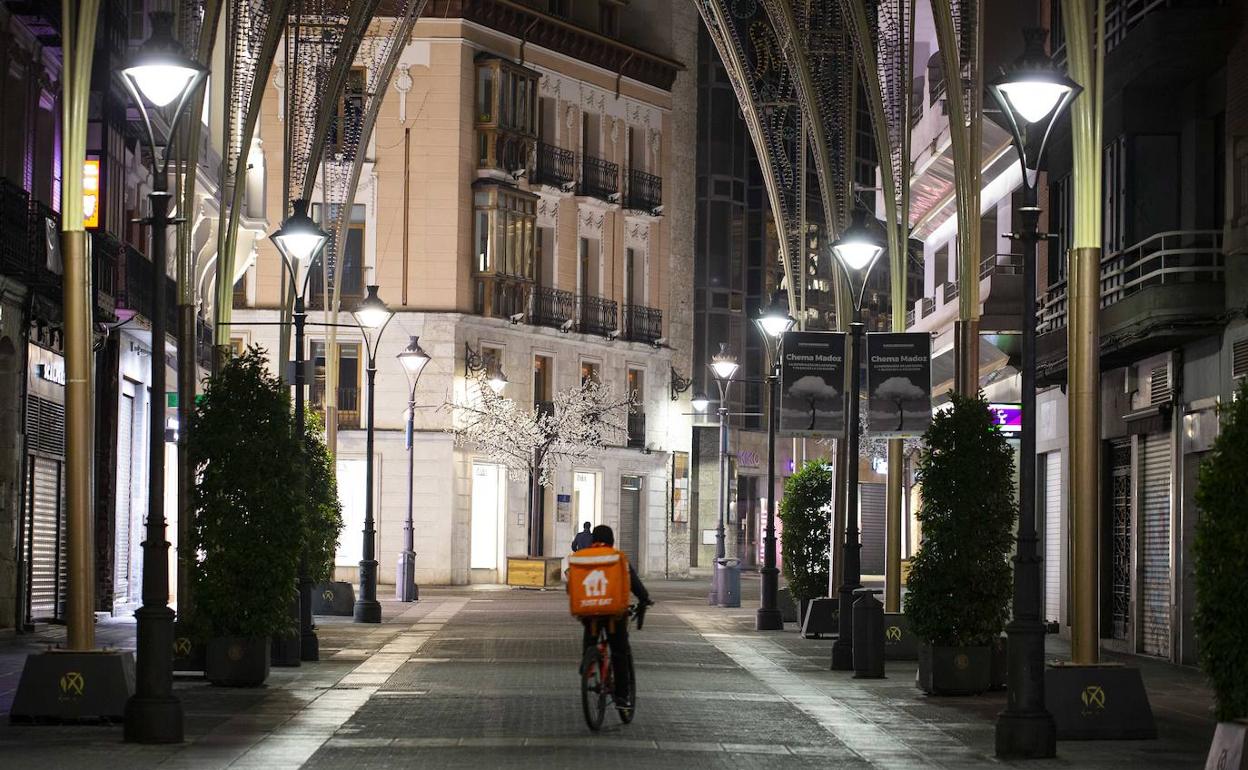 Un repartidor de comida a domicilio circula por el centro de la calle Santiago de Valladolid.
