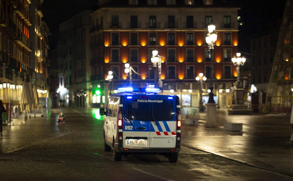 Un vehículo policial circula por la Plaza Mayor de Valladolid durante el toque de queda. 