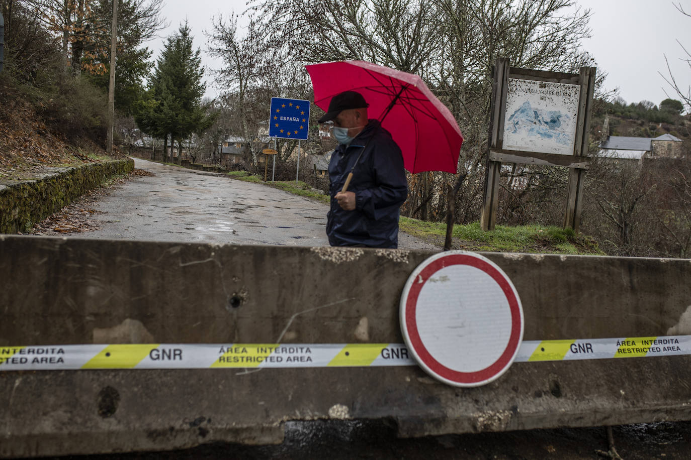 Un hombre pasea junto a la frontera por el lado español.