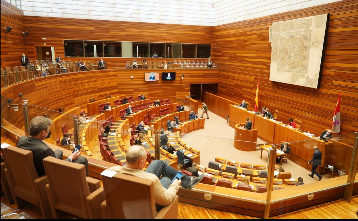 Procuradores repartidos por el hemiciclo y la tribuna de invitados para mantener la distancia covid.