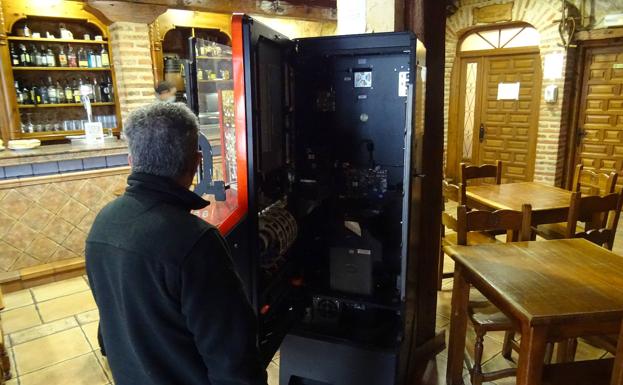 Un operario repara la tragaperras del bar Mirarríos de Puente Duero.