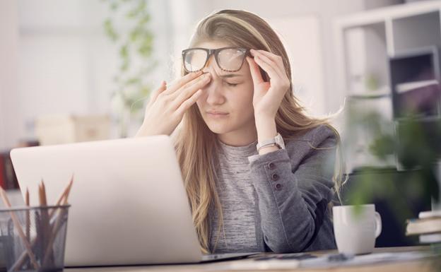 Una joven se toca los ojos, posiblemente por fatiga visual. 