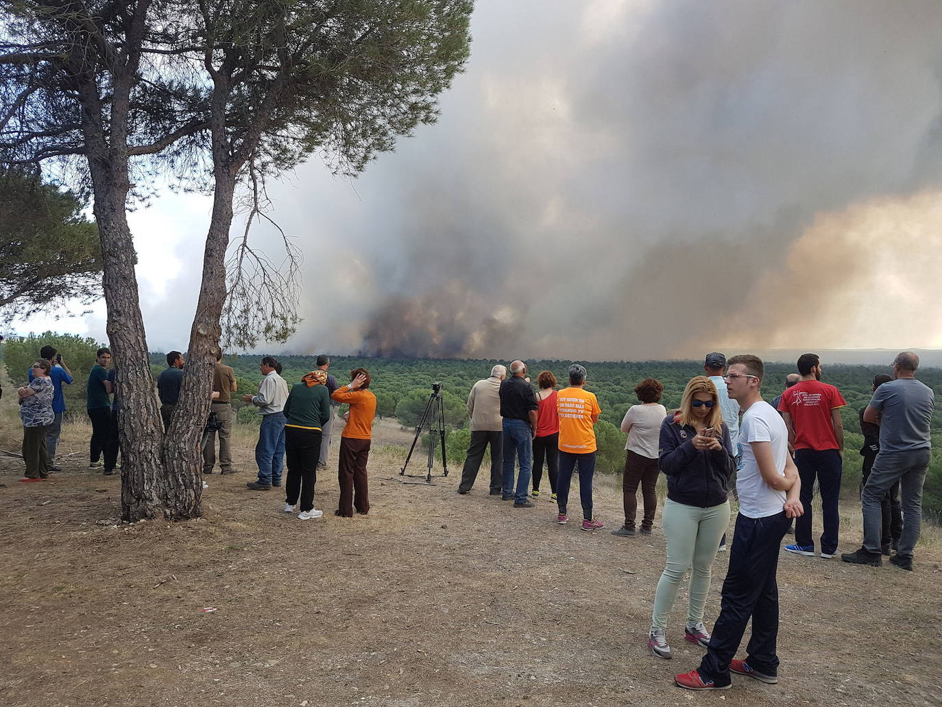 Vecinos observan el humo y las llamas del incendio en Nieva en abril de 2017.