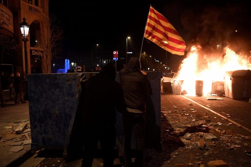 Varios manifestantes preparan una barricada en Barcelona.