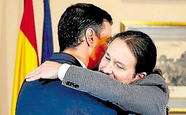 Pablo Iglesias se abraza con Pedro Sánchez tras la firma del pacto de Gobierno tras la súltimas generales.