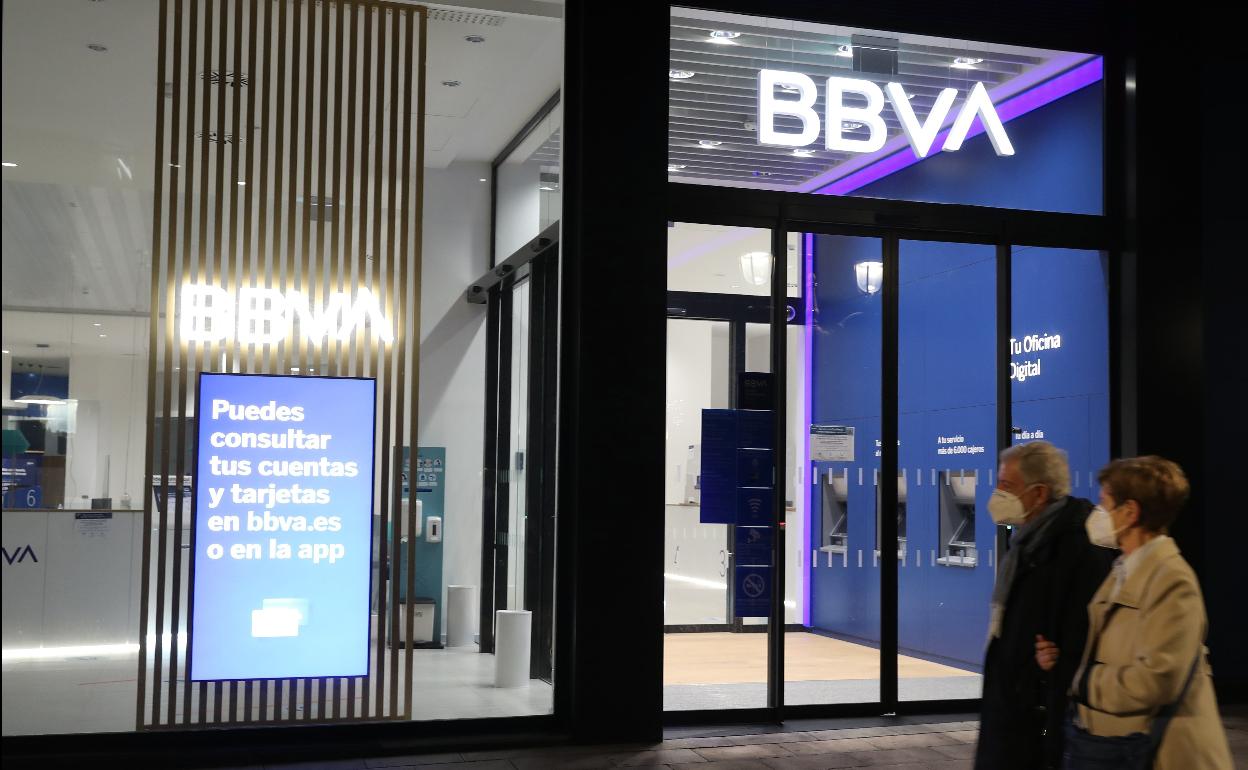 Una pareja pasa frente a una oficina del BBVA en Bilbao.