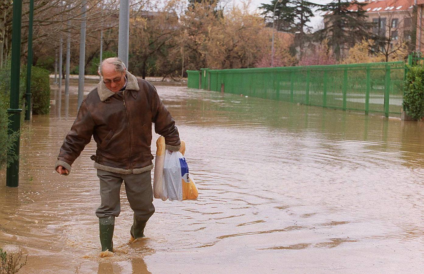 Un vecino del barrio Arturo Eyries intentaba llegar a su vivienda con la compra diaria, atravesando una calle totalmente anegada por la crecida del río.