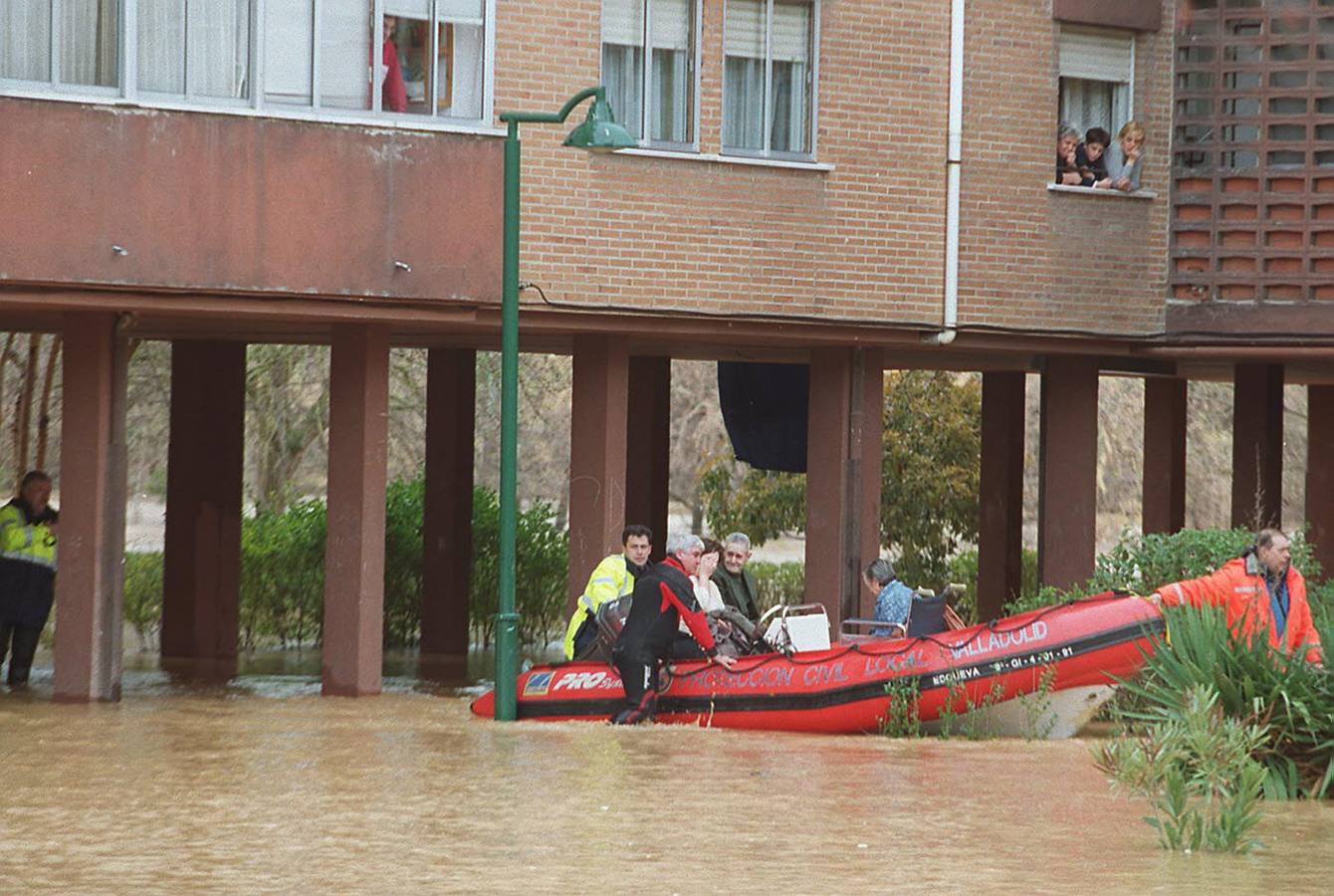 Bomberos y personal de Protección Civil trasladaban a varios vecinos del barrio Arturo Eyries de Valladolid que tuvieron que abandonar sus casas en lancha.