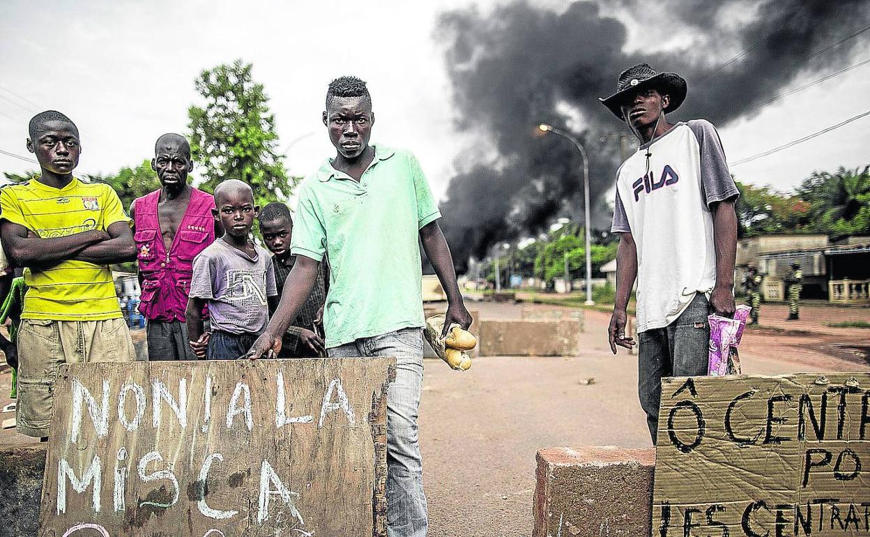 Un grupo de jóvenes muestran su enfado junto a una barricada en llamas tras el ataque perpetrado contra una iglesia.