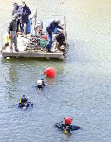 Imagen secundaria 2 - Buzos y voluntarios, durante la inmersión para el rescate de las bolas de piedra del Pisuerga.