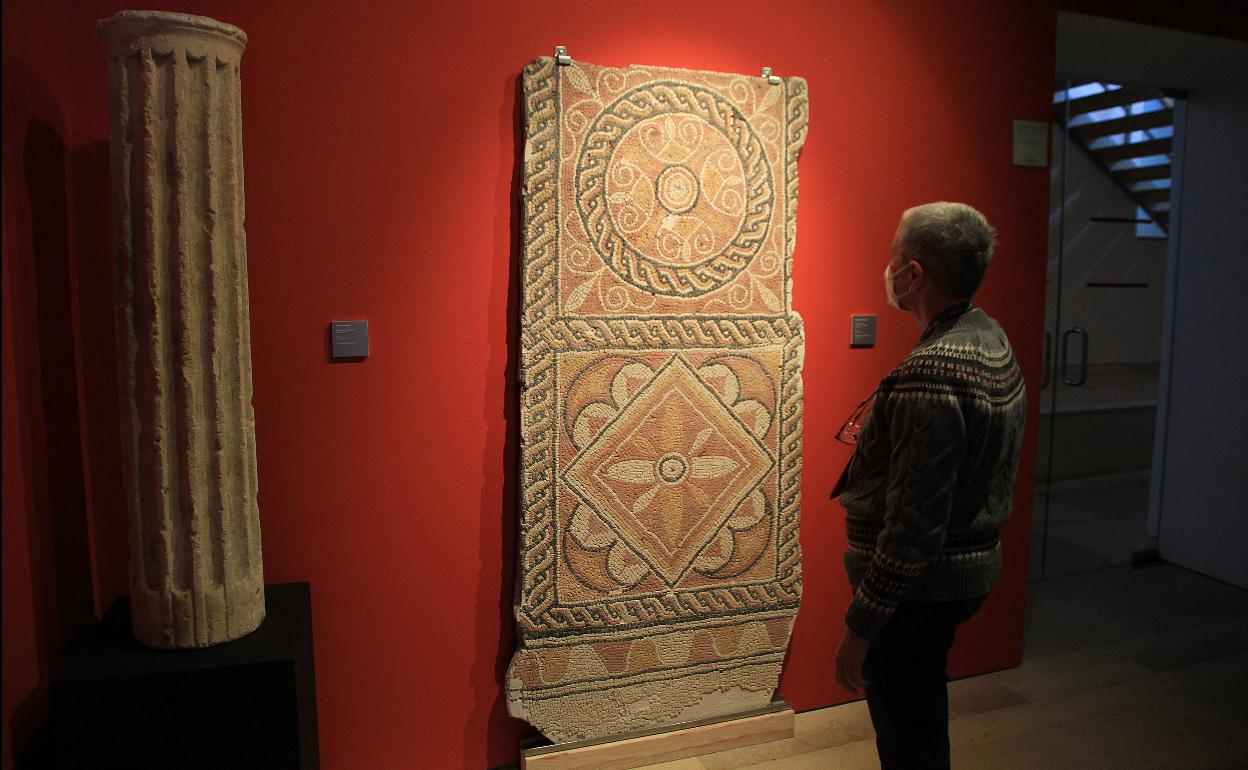 Un hombre observa el mosaico en el Museo de Segovia.