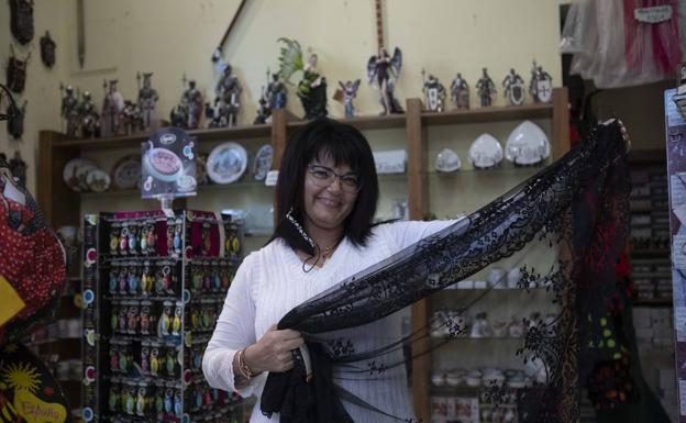 Montserrat Corrales enseña una mantilla en su tienda de souvenirs, situada en la calle Lencería de Valladolid.