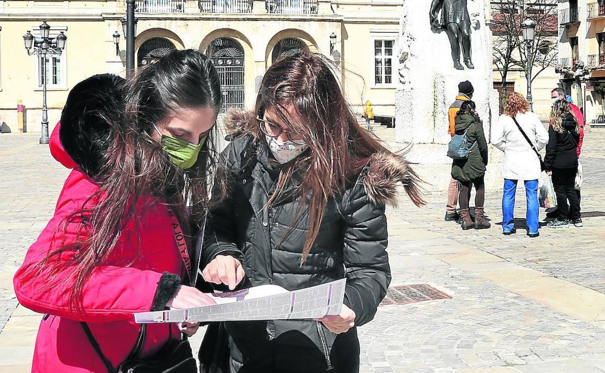 Dos jóvenes leonesas consultan un plano en la Plaza Mayor de Palencia.