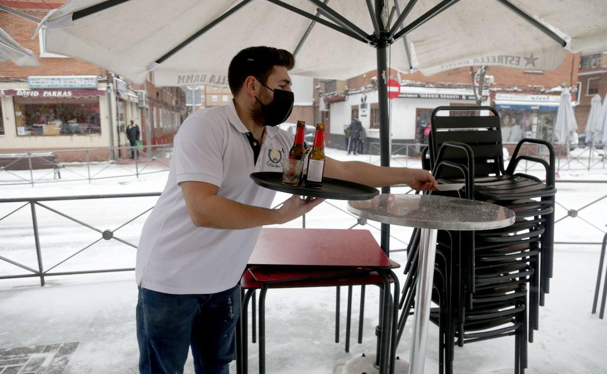 U n camarero recoge las mesas del bar Justo, en la calle Cardenal Cisneros (valladolid)
