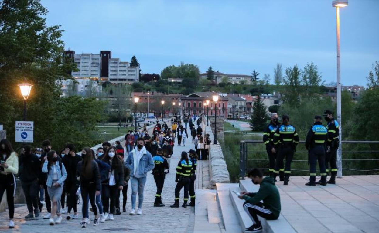 Agentes de la Policía controlan la salida de los jóvenes que se habían concentrado en la zona del Puente Romano.