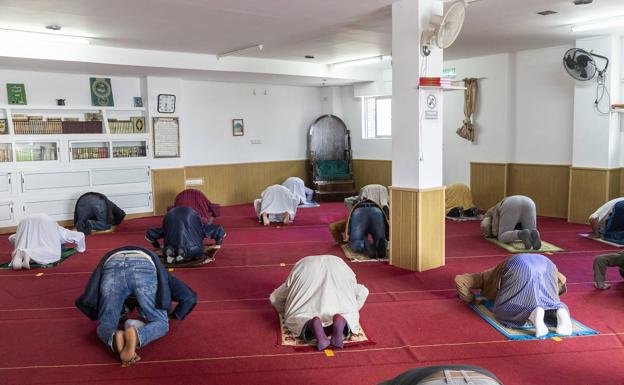 Imagen principal - Imágenes de musulmanes rezando, en el centro, el imán de la Mezquita, Ghouzali Abdelouahad.