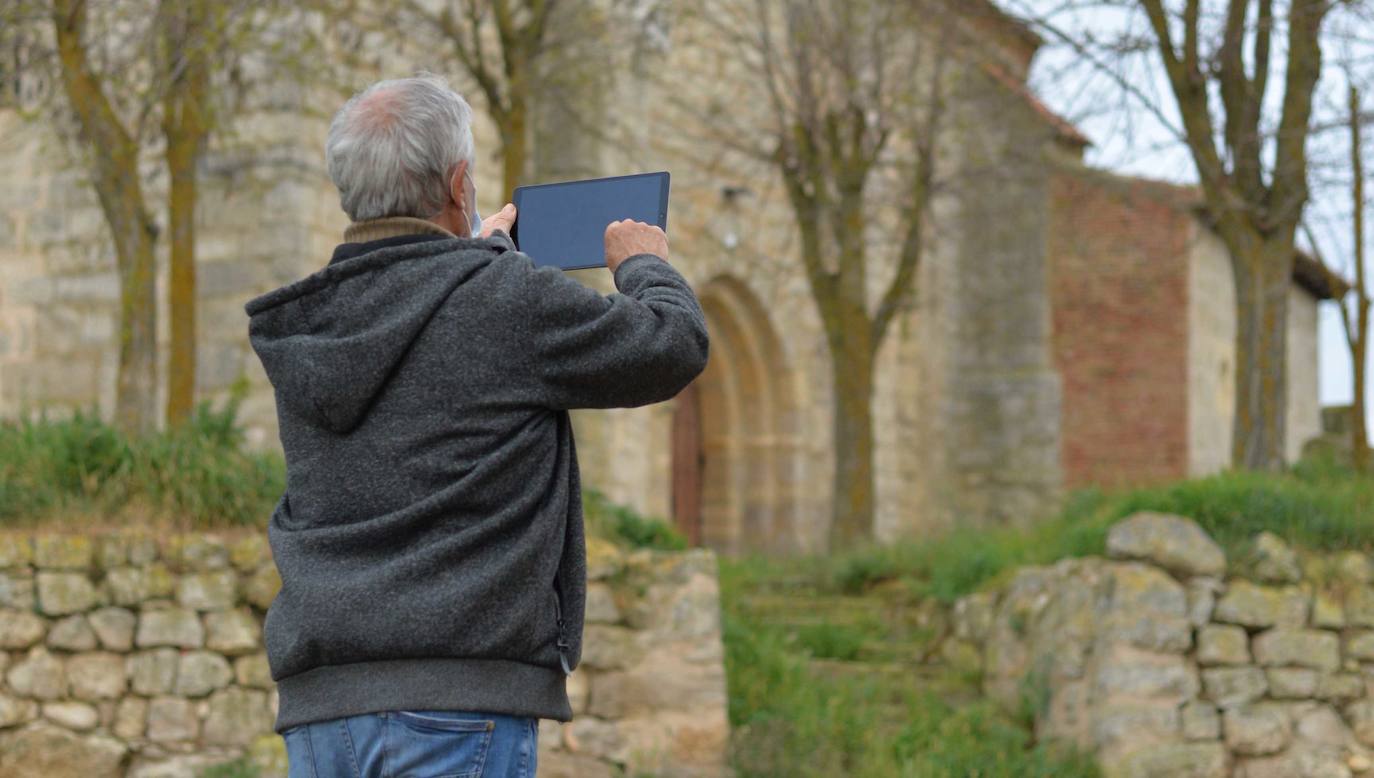 Un vecino trata de establecer conexión con una tablet junto a la iglesia de Amayuelas de Arriba. 