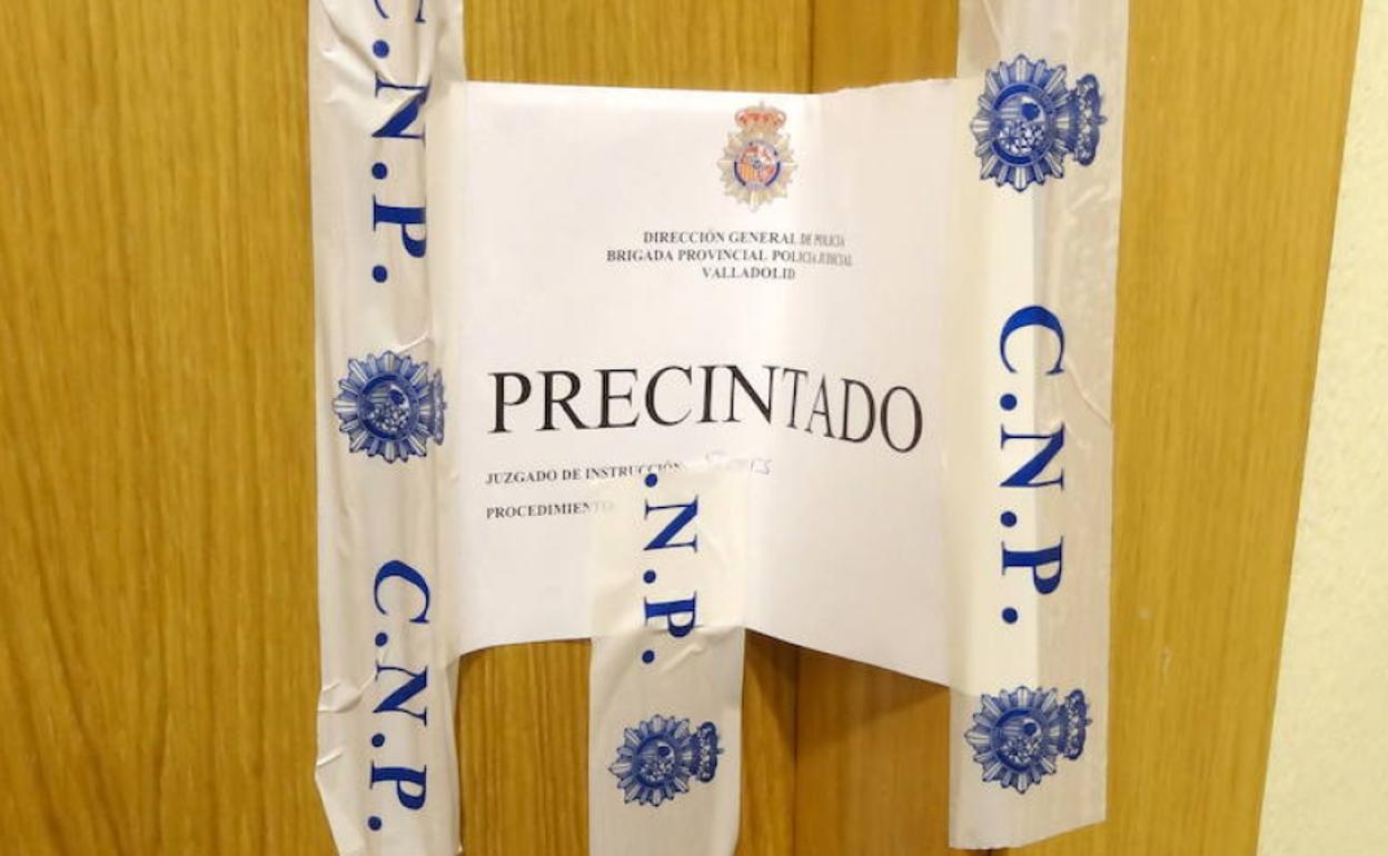 El precinto de la puerta de una casa en cuyo interior una persona supuestamente se ha suicidado. 