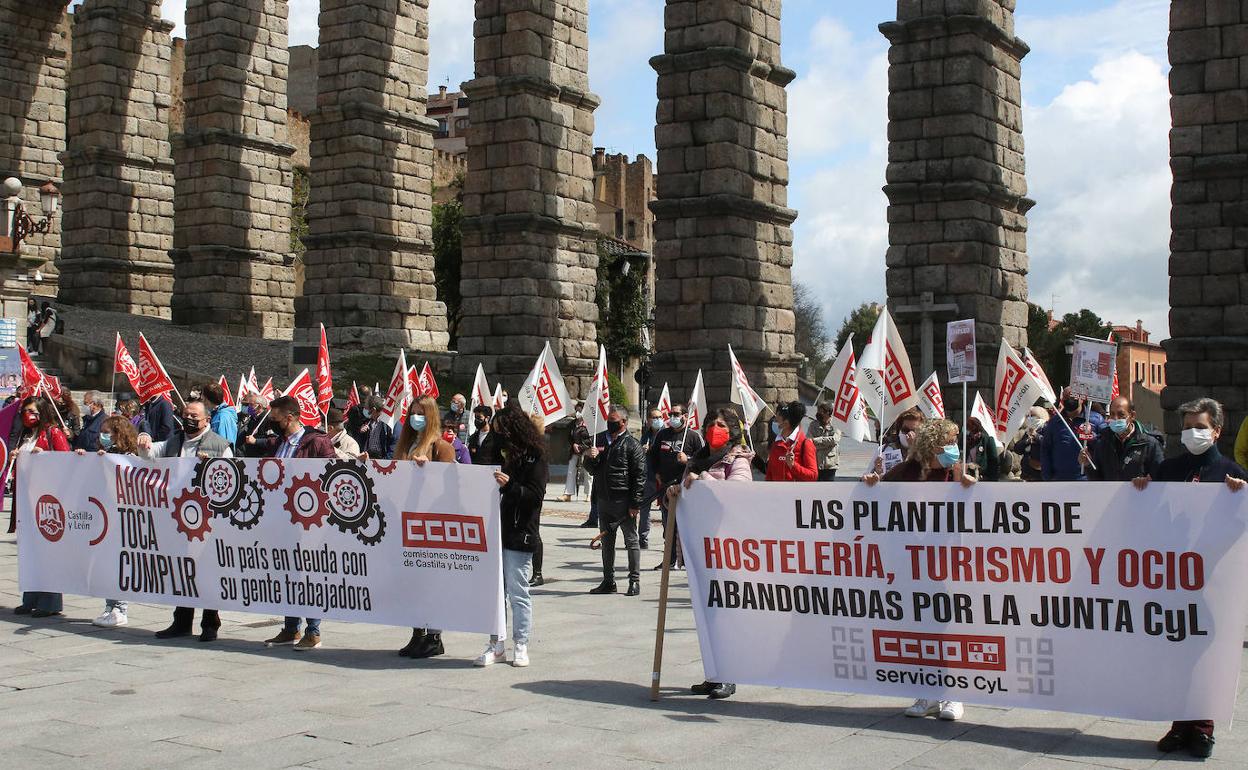 Grupo de manifestantes sujetan una pancartas a los pies del Acueducto en el Primero de Mayo. 