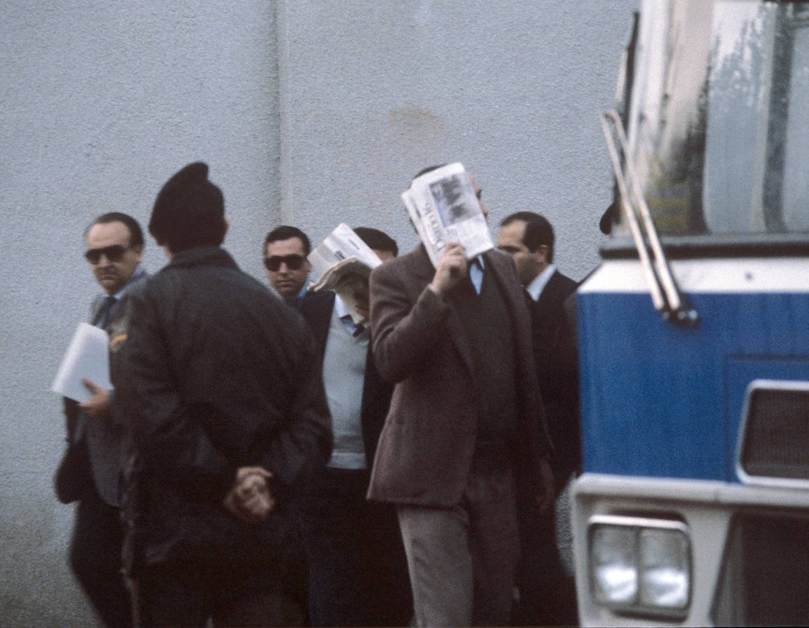 30.03.87 Los 38 acusados en el 'juicio de la colza' se tapan la cara con periódicos a su llegada a sala habilitada, en el auditorium de la Casa del Campo, donde se inició la lectura de un resumen de la causa, por el secretario judicial.