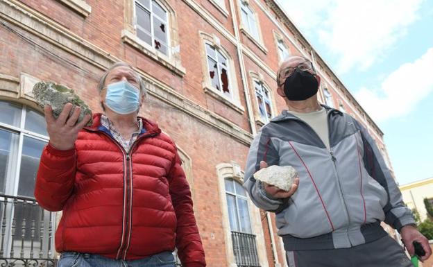 Julio Negro y Juan Lorenzo muestran algunas de las piedras que lanzaron los vándalos.
