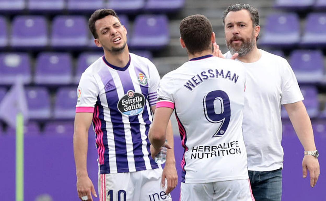 Sergio González y Shon Weissman chocan las manos al final del partido al lado de un Óscar Plano exhausto