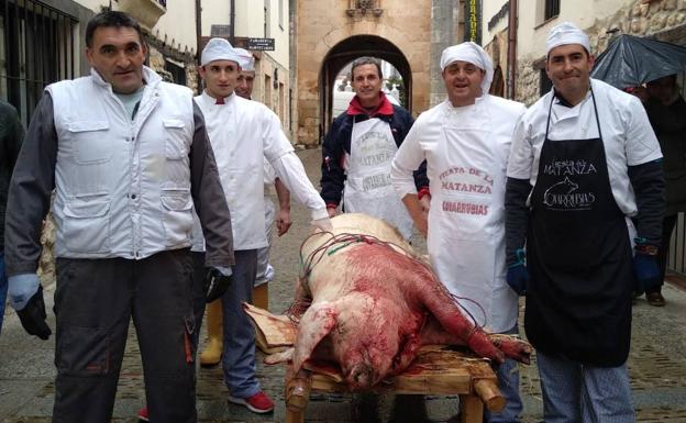 Los matarifes con el marrano durante la Fiesta de la Matanza.