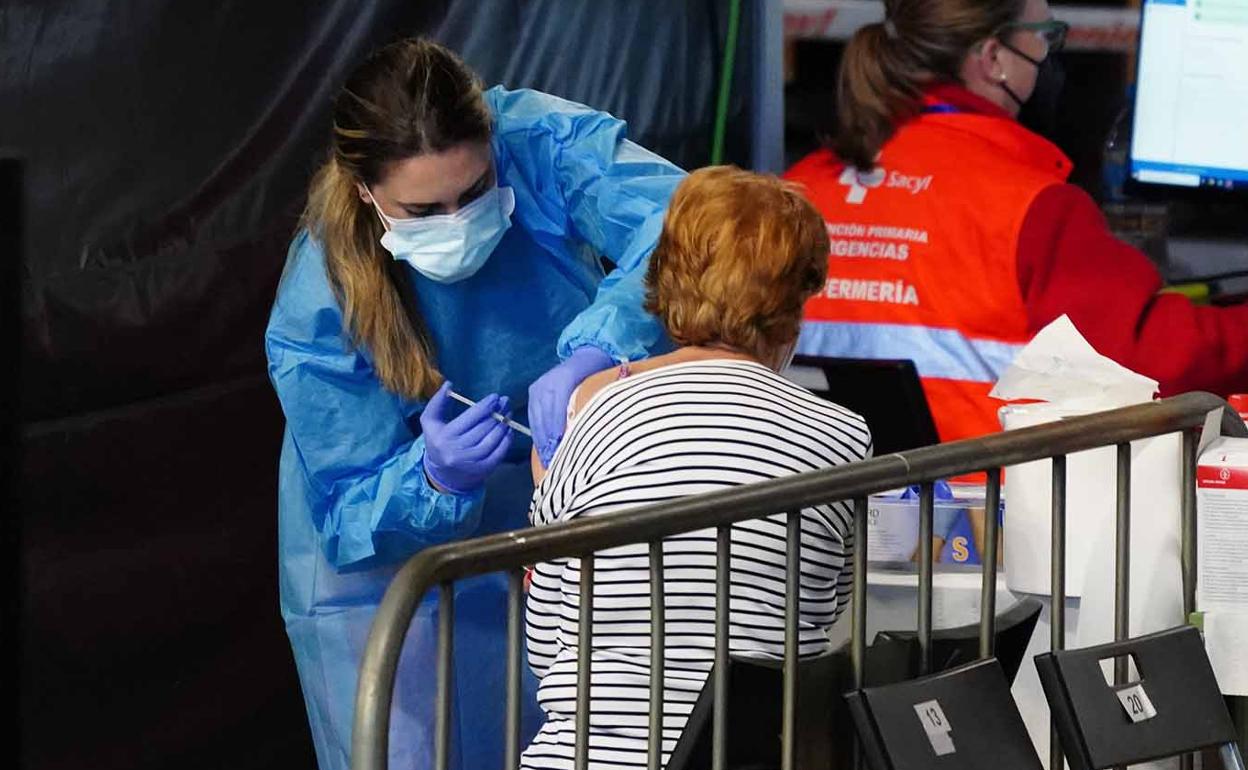Una mujer recibe la primera dosis de la vacuna 