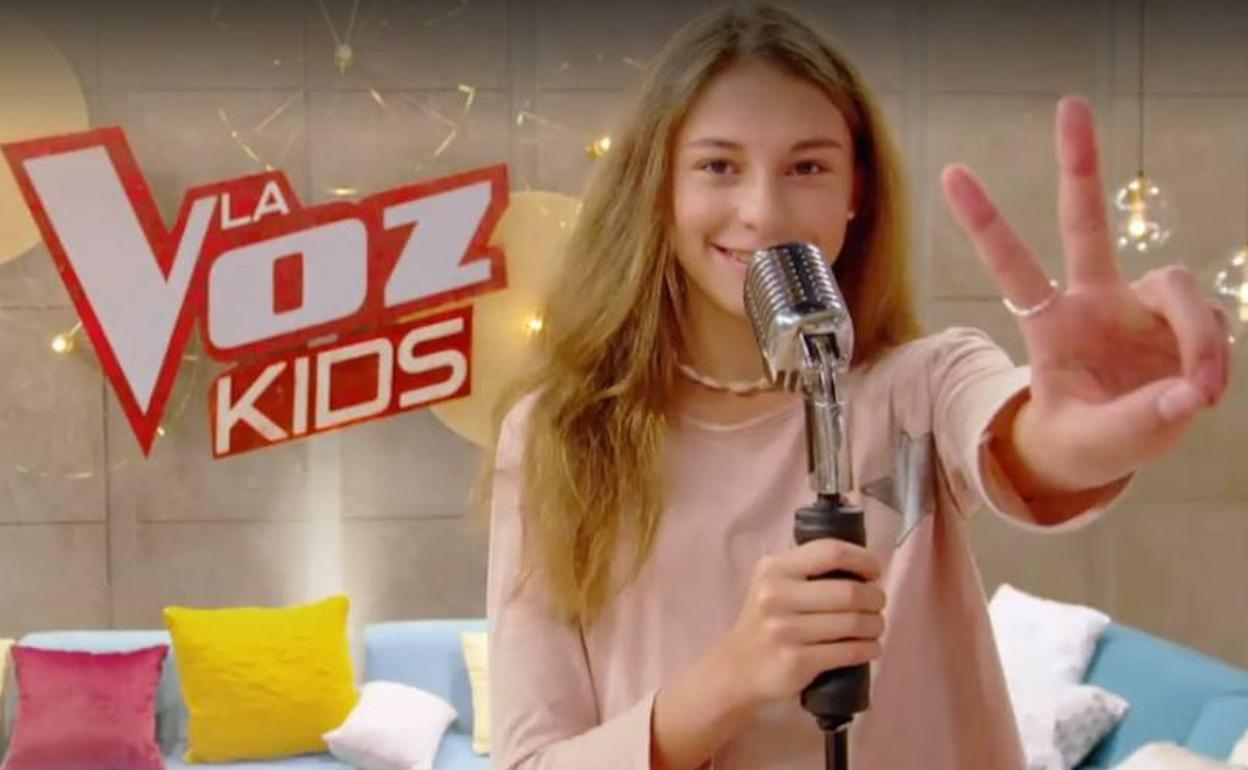 Carmen saluda a cámara con la v de La Voz Kids. 