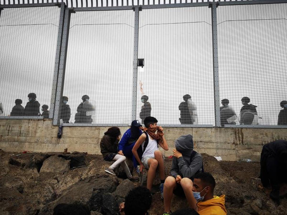 Miembros de la policía Nacional vigilan la verja que separa Ceuta de la localidad de Fnideq (Castillejos).