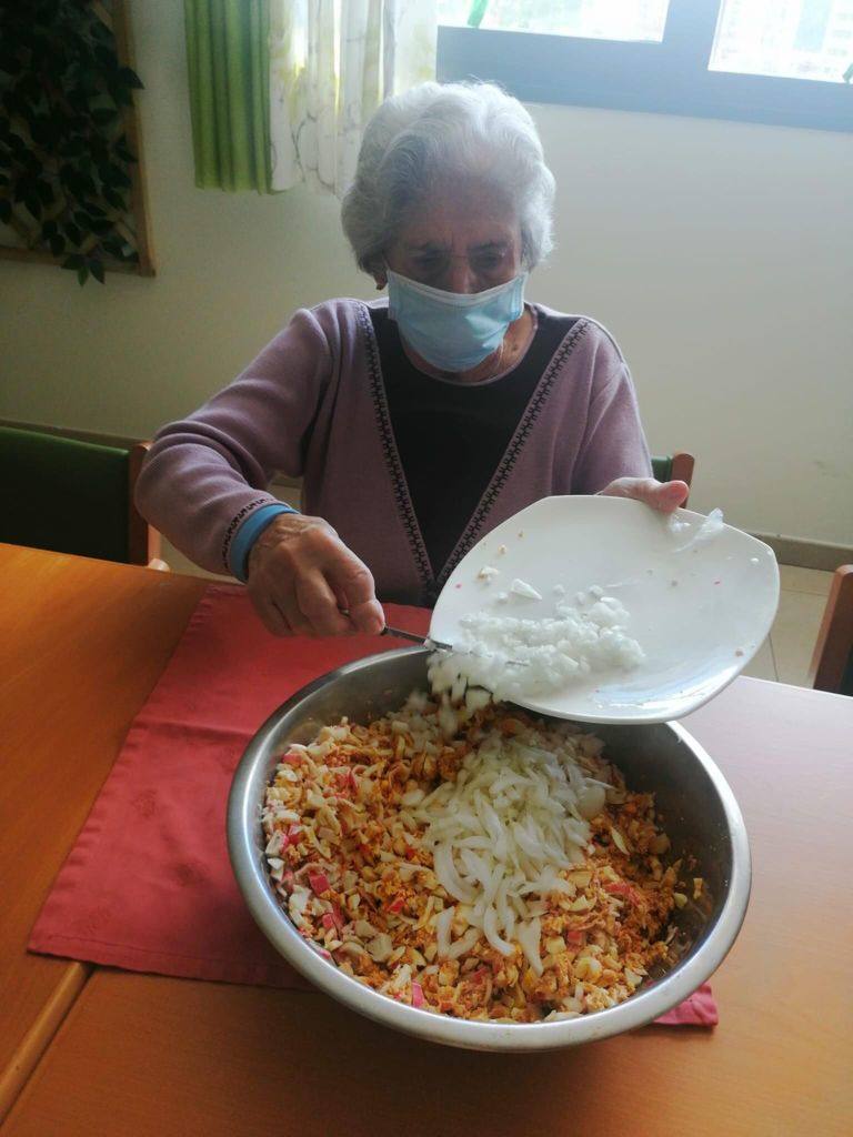Un grupo de mayores de Adanda de Duero colaboran en la preparación de un canapé.