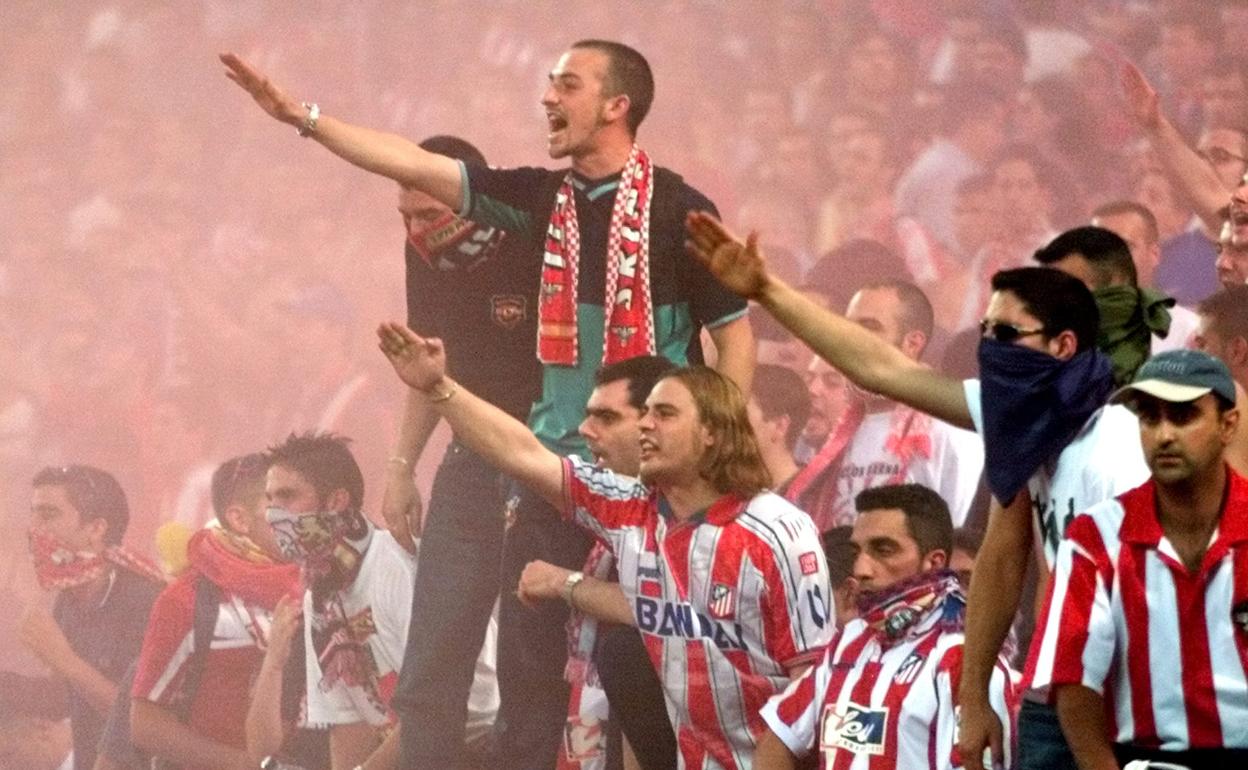 Aficionados del Atlético de Madrid lanzan bengalas durante un partido. 