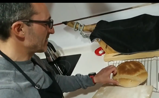Manuel coloca el pan en una rejilla tras sacarlo del horno.