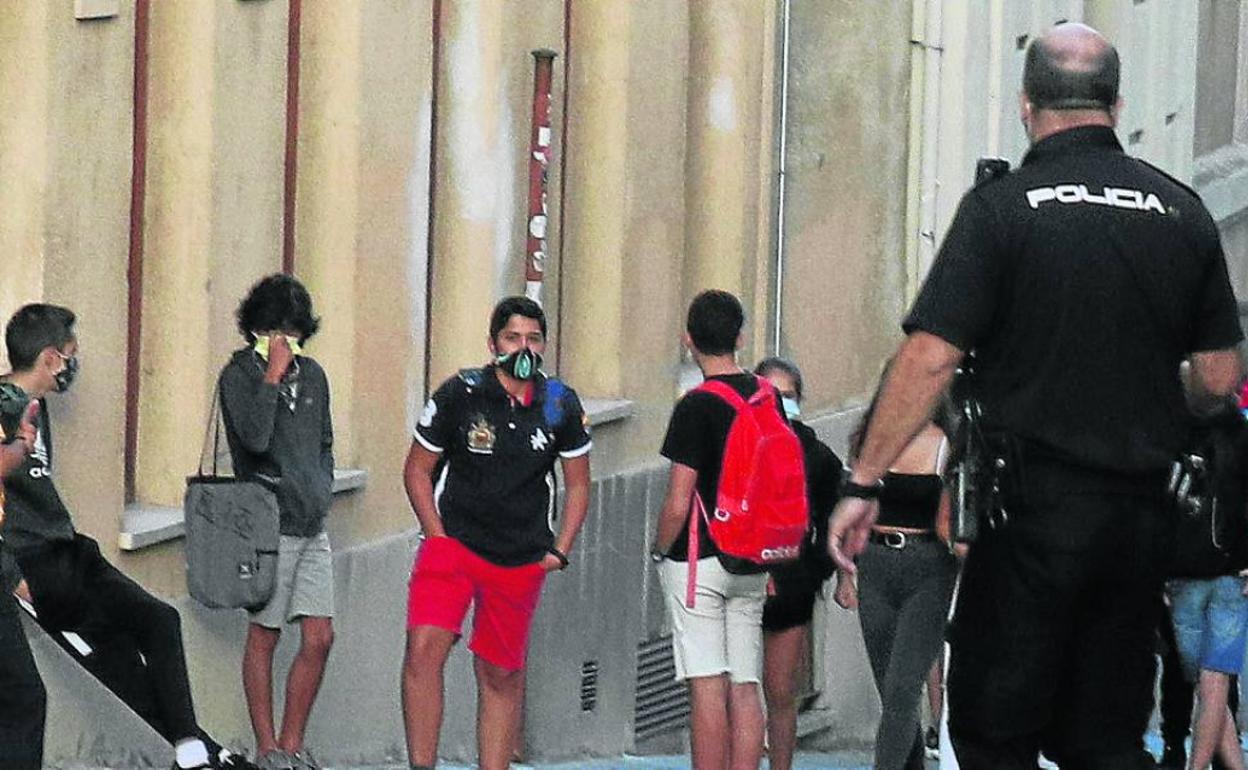 Dos policías nacionales controlan las inmediaciones de un centro docente en Segovia. 