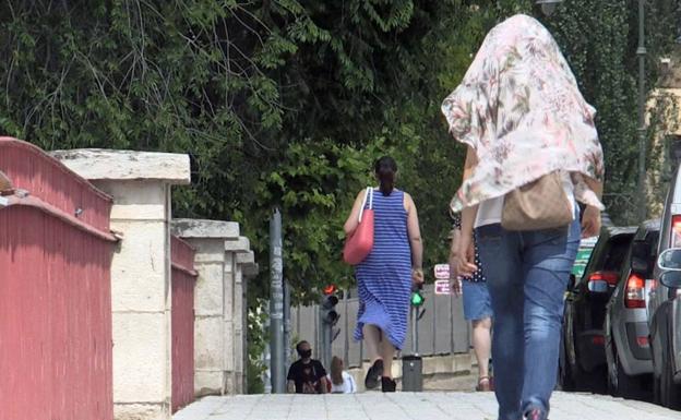 Una mujer se protege del calor con un pañuelo en la cabeza. 