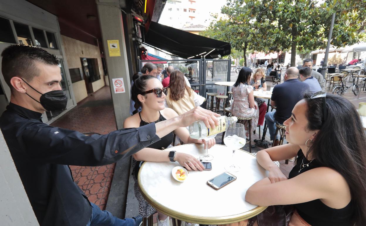 Un camarero atiende a dos clientas en una terraza del centro de Valladolid.