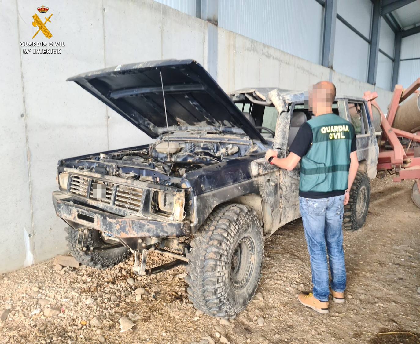 Un guardia civil, junto al vehículo robado. 