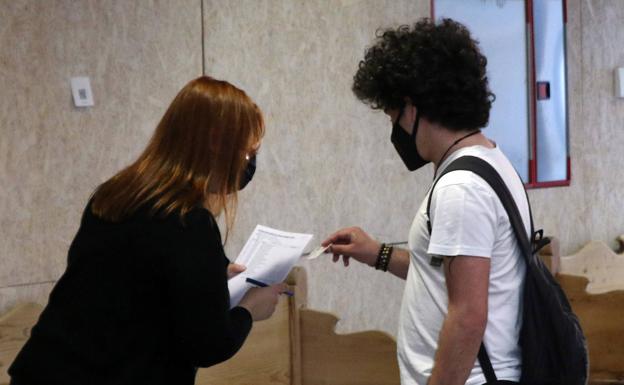 Imagen. Un joven consulta sus datos para acceder a la clase donde le toca hacer la prueba. 