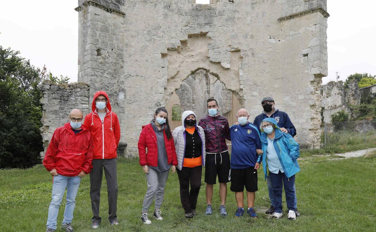 miembros de la Asociación Amigos de la Armedilla posan junto al corredor Víctor Manuel Sacristán, quinto por la izquierda, y el monasterio de fondo.