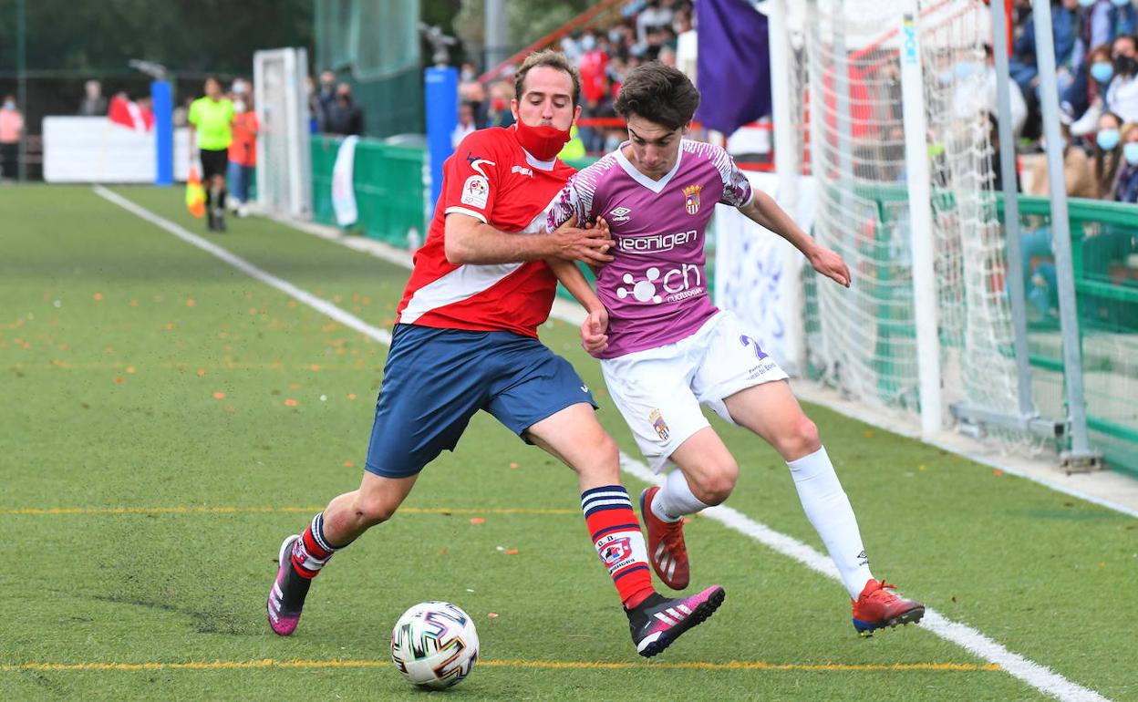 Dos jugadores luchan por el control del balón en una acción en banda. 